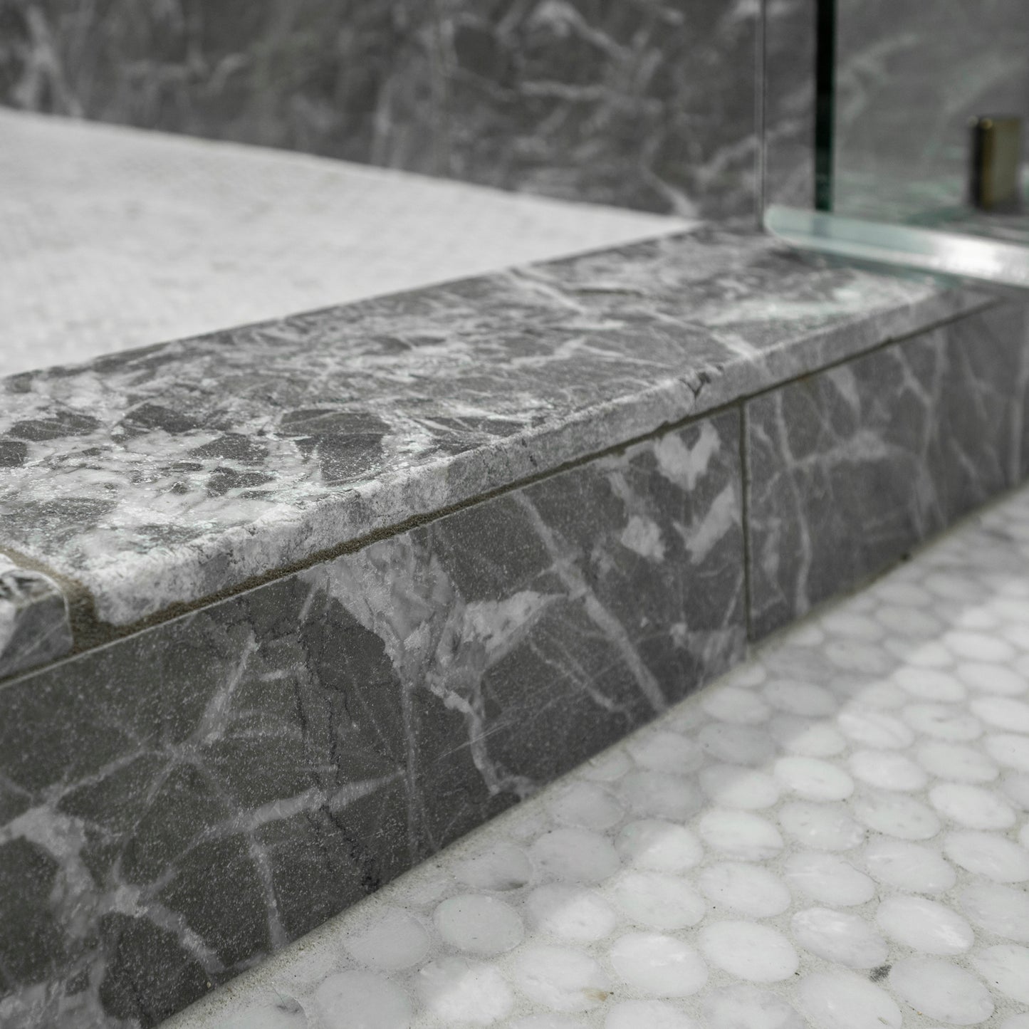 Gray marble shower step with a textured finish