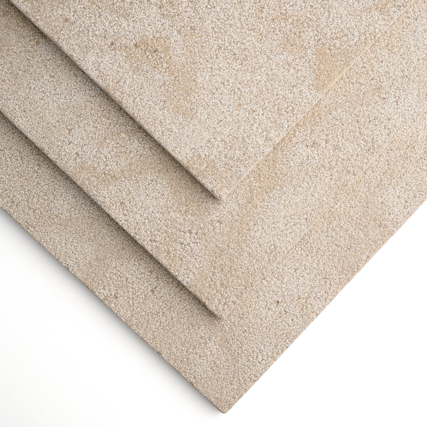 Three overlapping rectangular limestone tile in a warm light beige/taupe, shown on a clean white background.