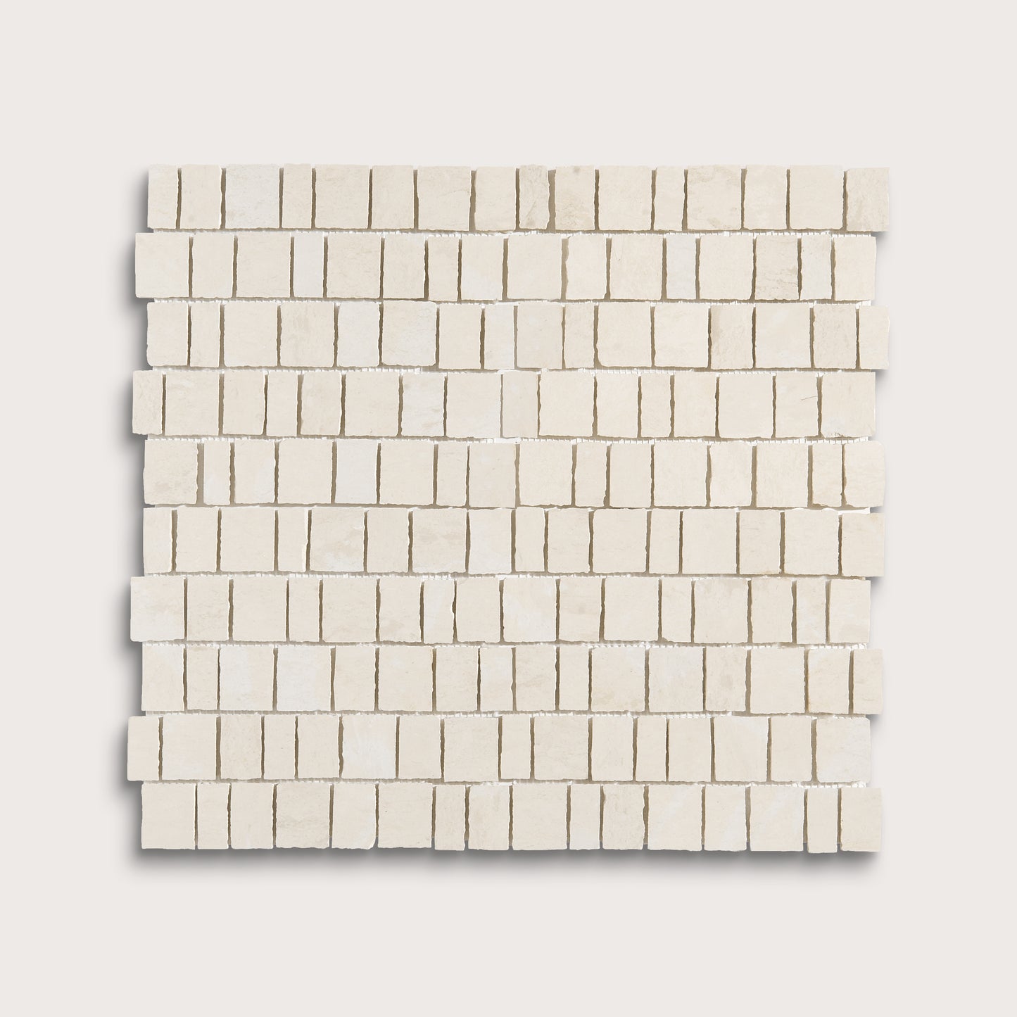 A square mosaic tile sample made of small rectangular off-white stone pieces arranged in staggered rows, shown on a light neutral background.