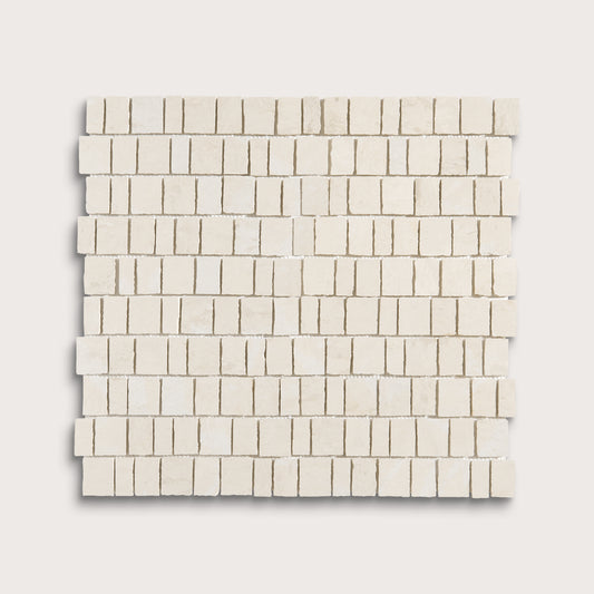 A square mosaic tile sample made of small rectangular off-white stone pieces arranged in staggered rows, shown on a light neutral background.