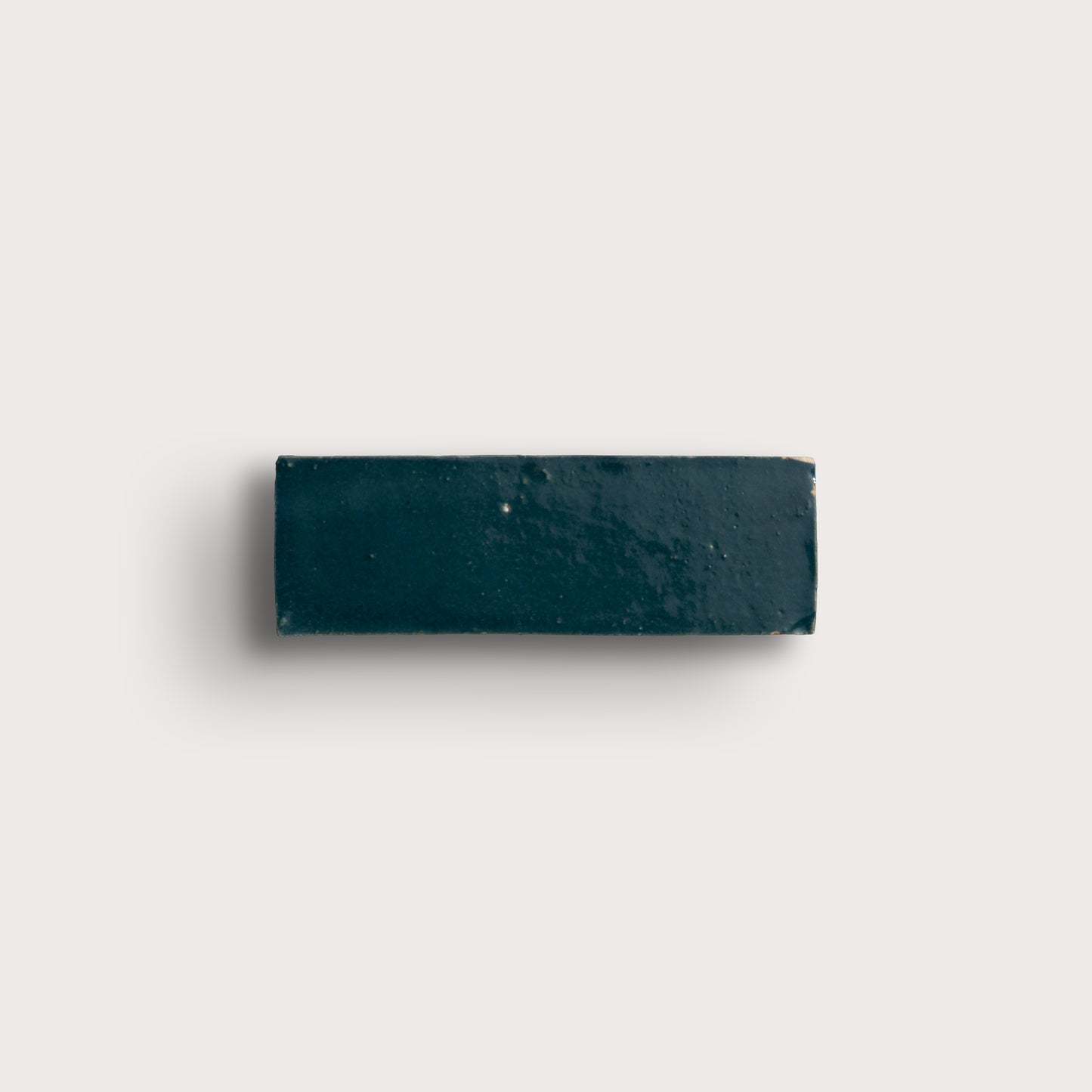 Rectangular zellige dark blue tile on a light gray background