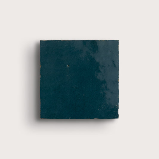 Square dark blue zellige tile on a light gray background