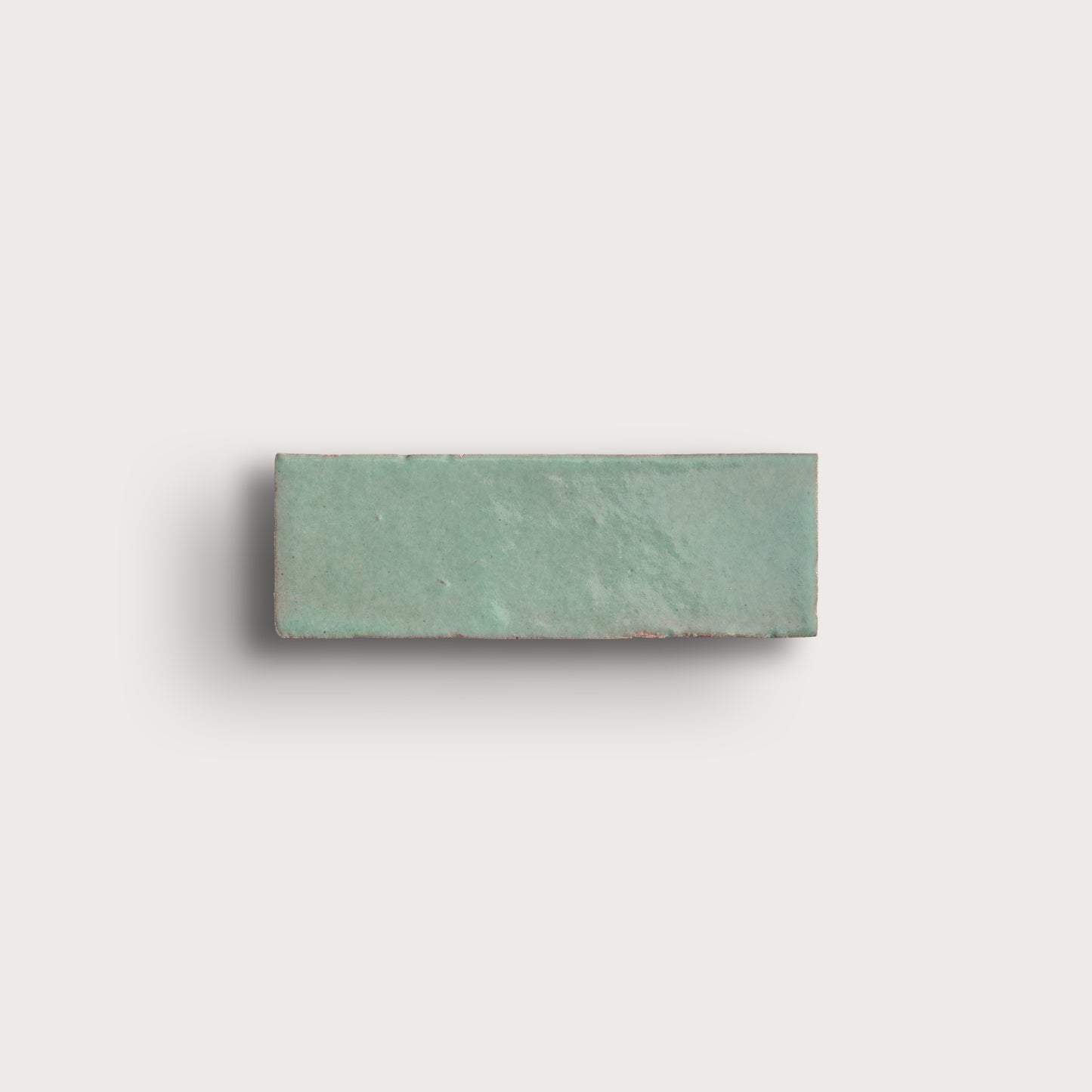 Rectangular green zellige tile on a light gray background