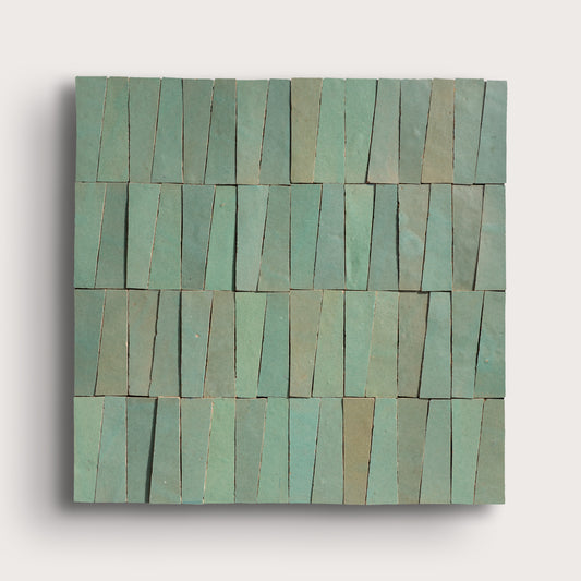 Rectangular green zellige tile with a pattern of horizontal stripes on a light gray background