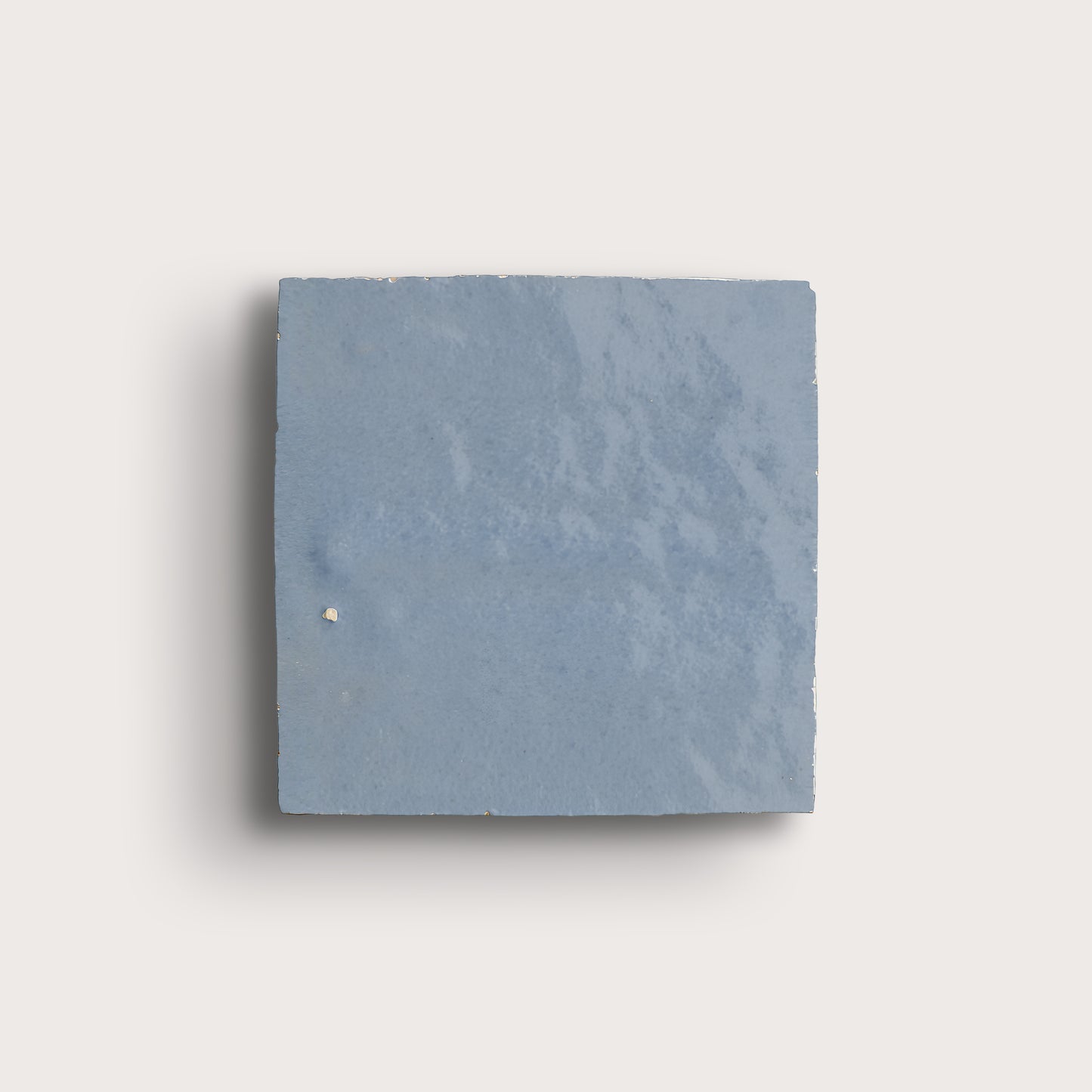 Square zellige blue tile on a light gray background