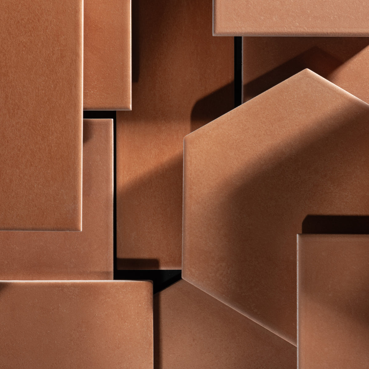 Close-up of geometric terracotta tiles, arranged in an abstract layered composition.