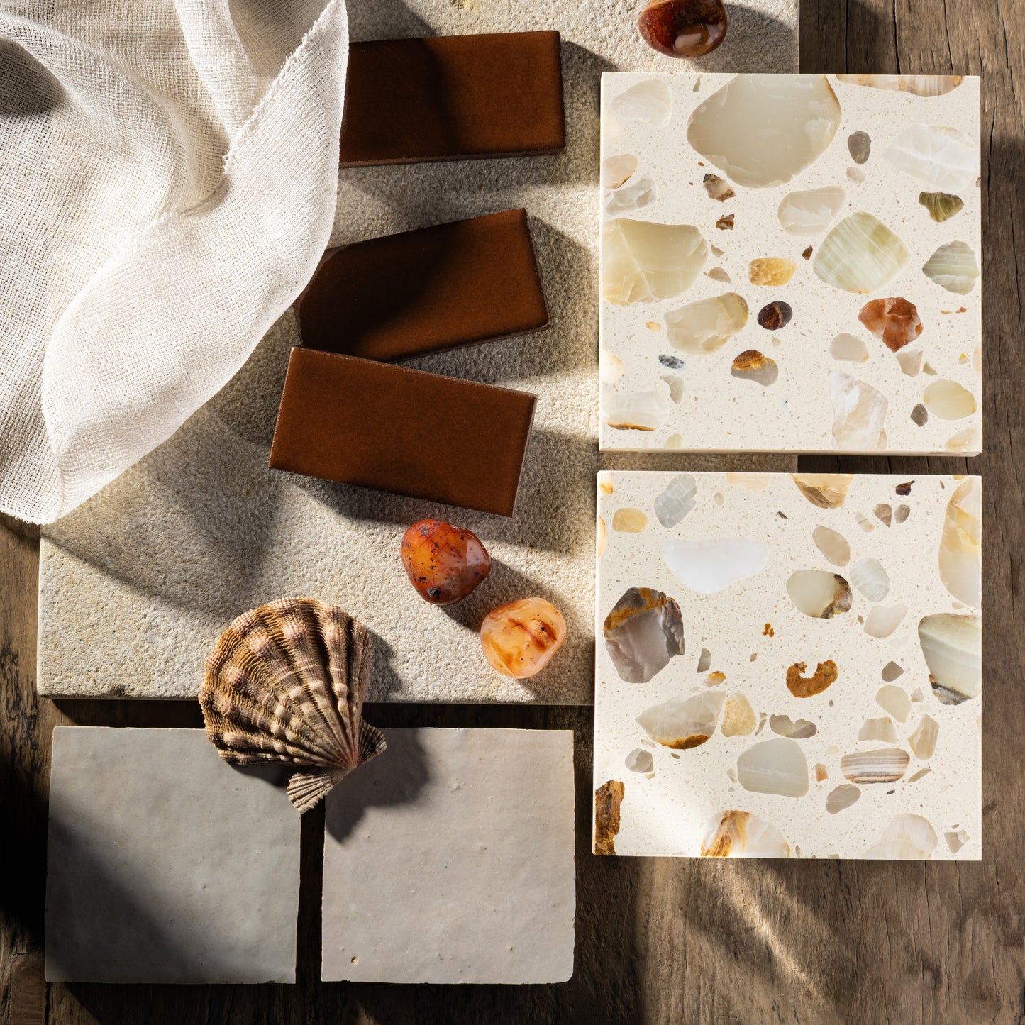 Terrazzo tiles with natural stone patterns on a wooden surface.