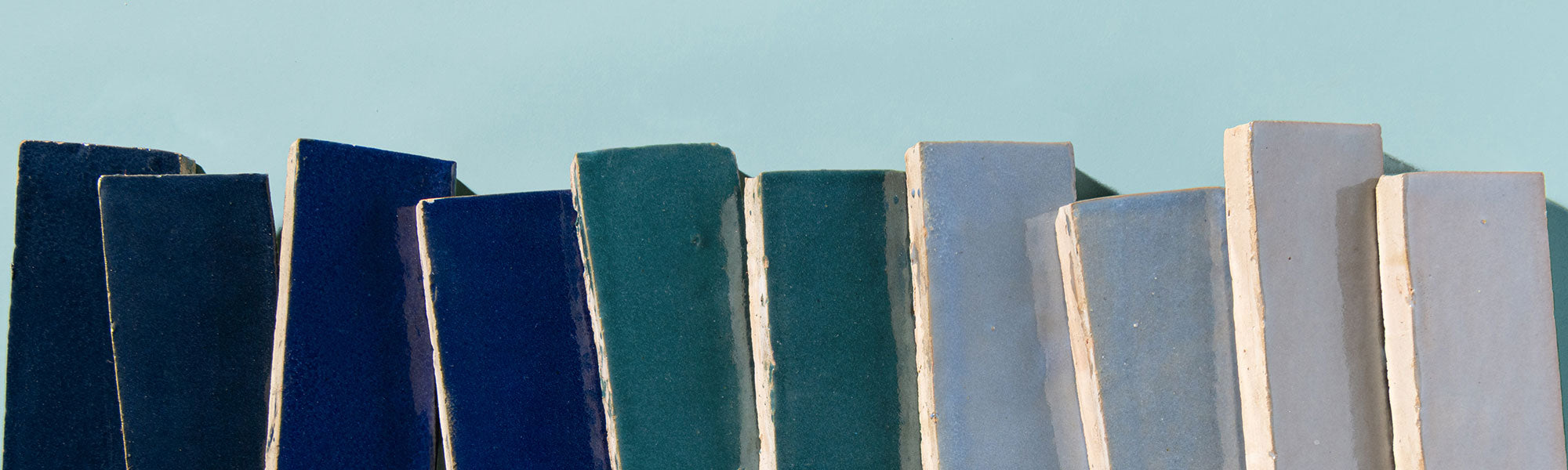 blue zellige rectangle tiles in a line on a blue background