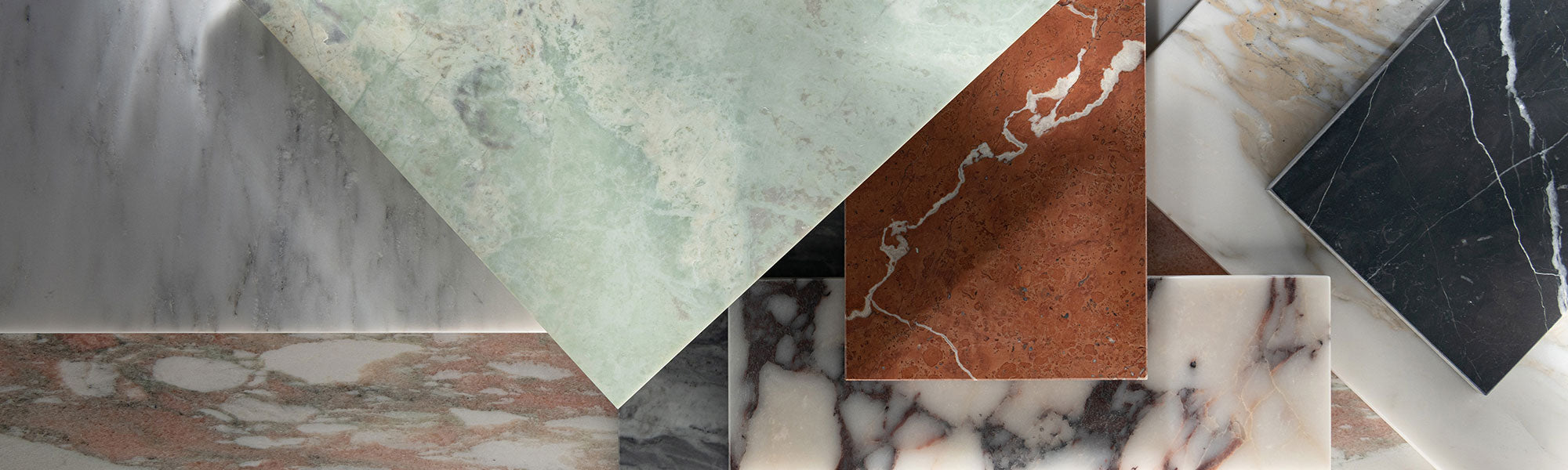 different marble tiles stacked together in grey, green, red, pink, and black