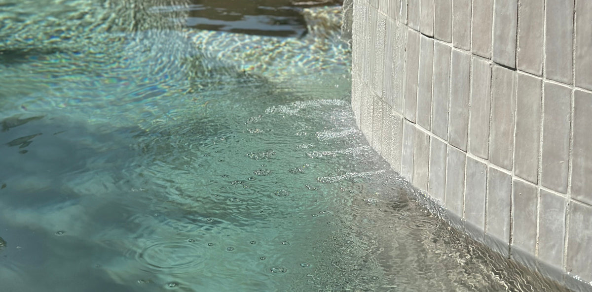 Pool tile close-up with waterline detail and textured gray swimming pool tiles