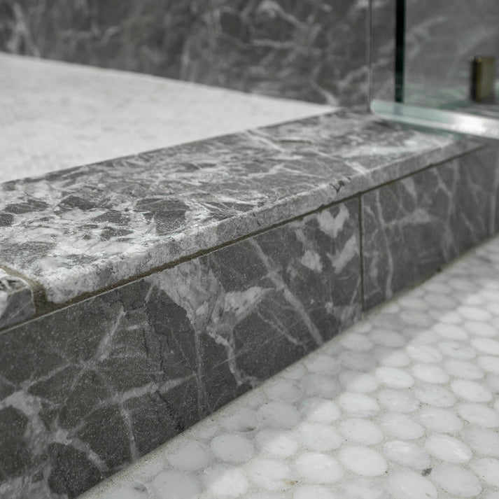 Gray marble shower step with a textured finish