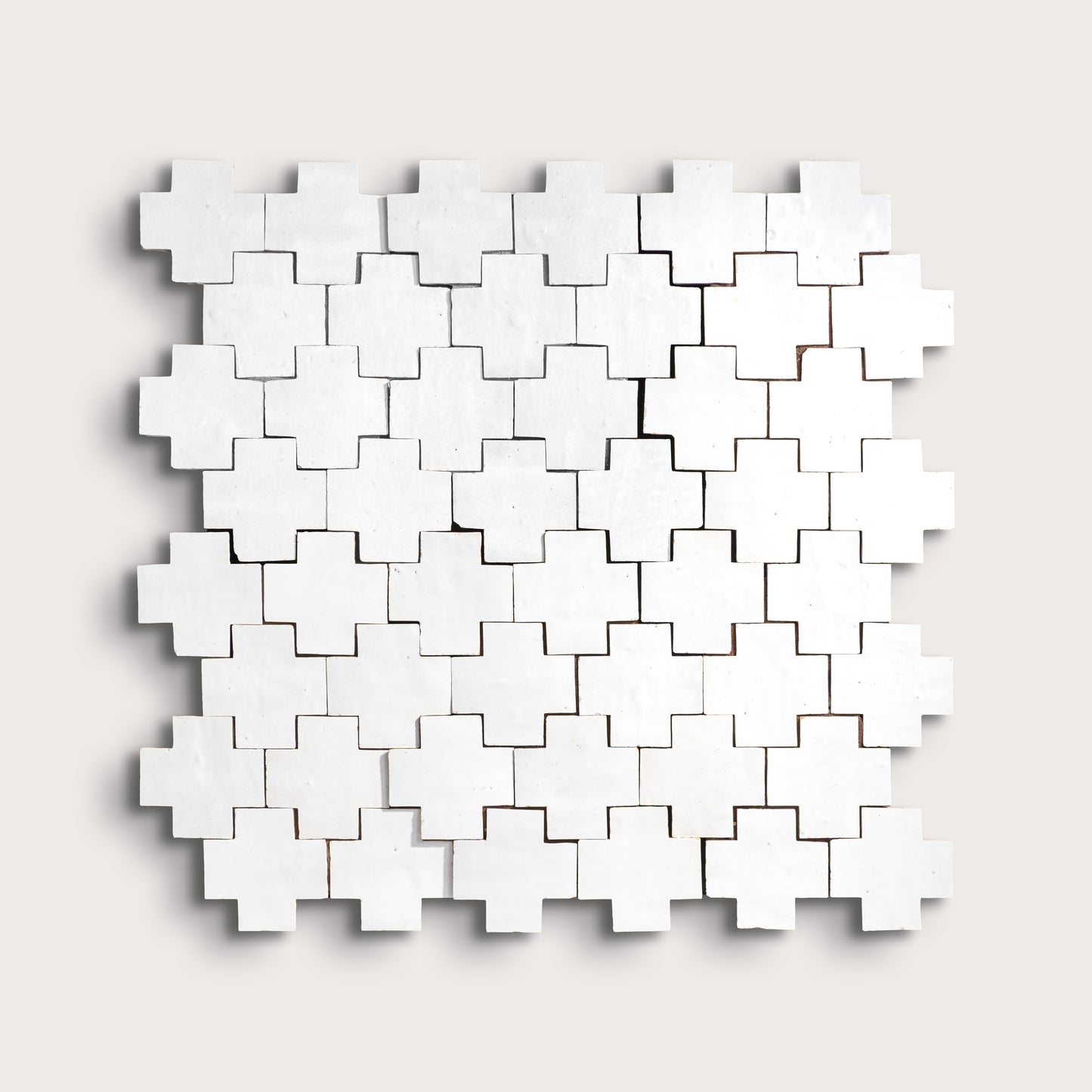 white zellige cross geometric design on a light gray background