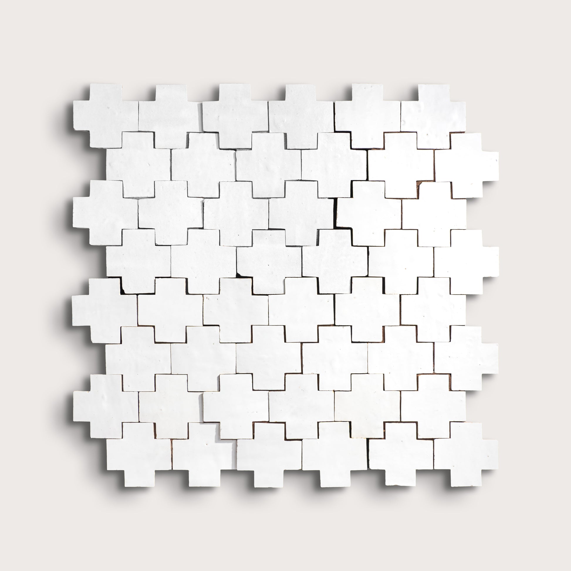 white zellige cross geometric design on a light gray background
