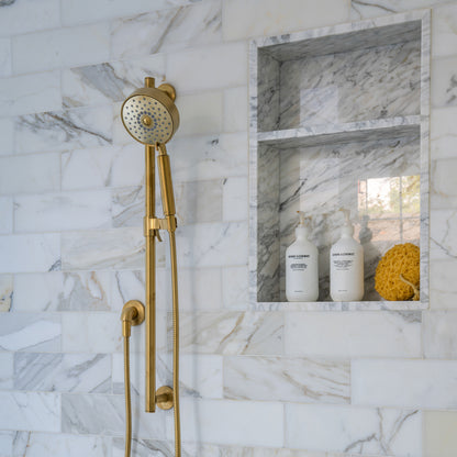 calacatta gold subway tile installed on the wall of a shower