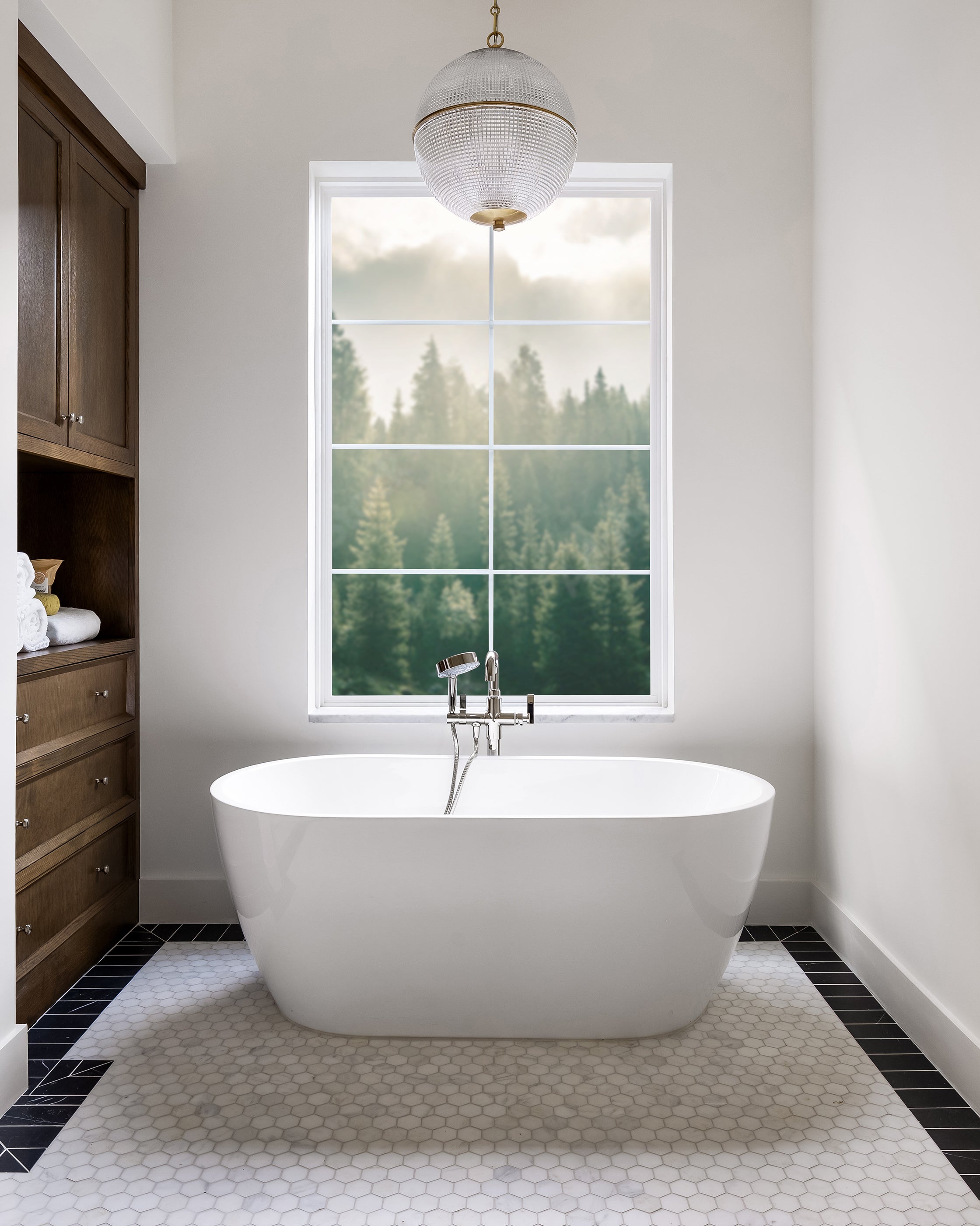 Modern bathroom with freestanding bathtub, and marble hexagon floor tile. 