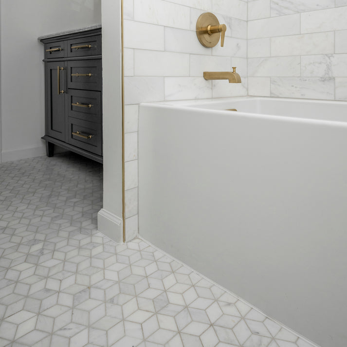 Bathroom with white bathtub, marble floor, and dark wooden cabinet.