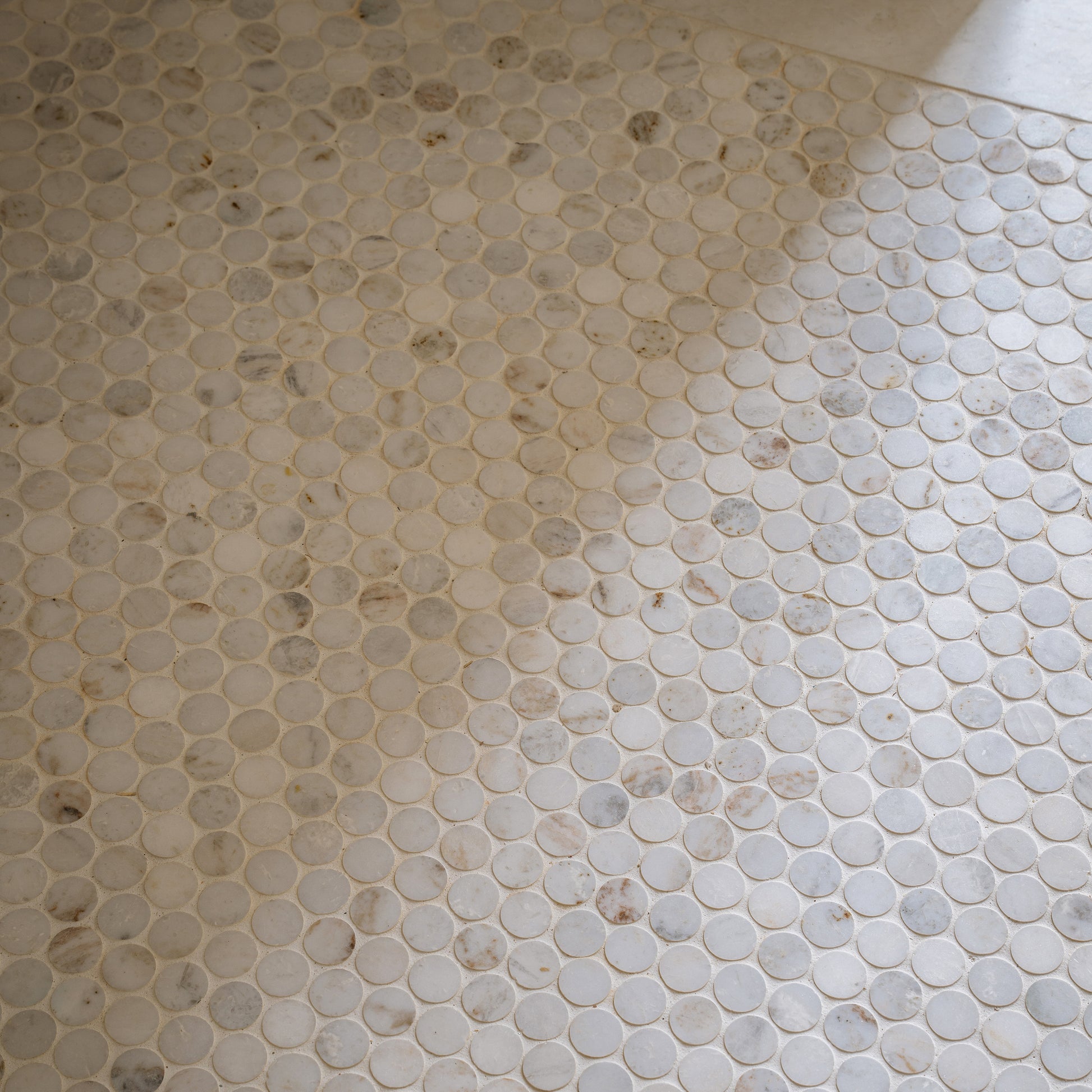 Close-up of a tiled floor with hexagonal casablanca carrara marble stone tiles.