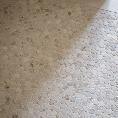 Close-up of a tiled floor with hexagonal casablanca carrara marble stone tiles.