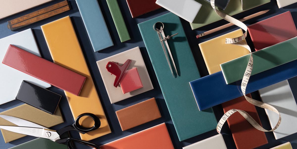 colorful ceramic tiles arranged in a mood board with scissors, pencils, and tape measure
