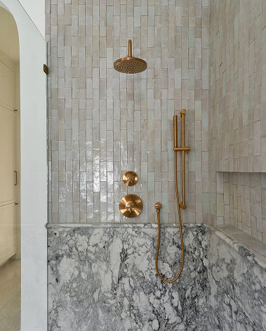 zellige and marble tile in shower with brass fixtures