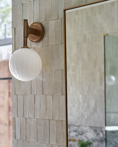 brass sconce on a zellige tiled wall