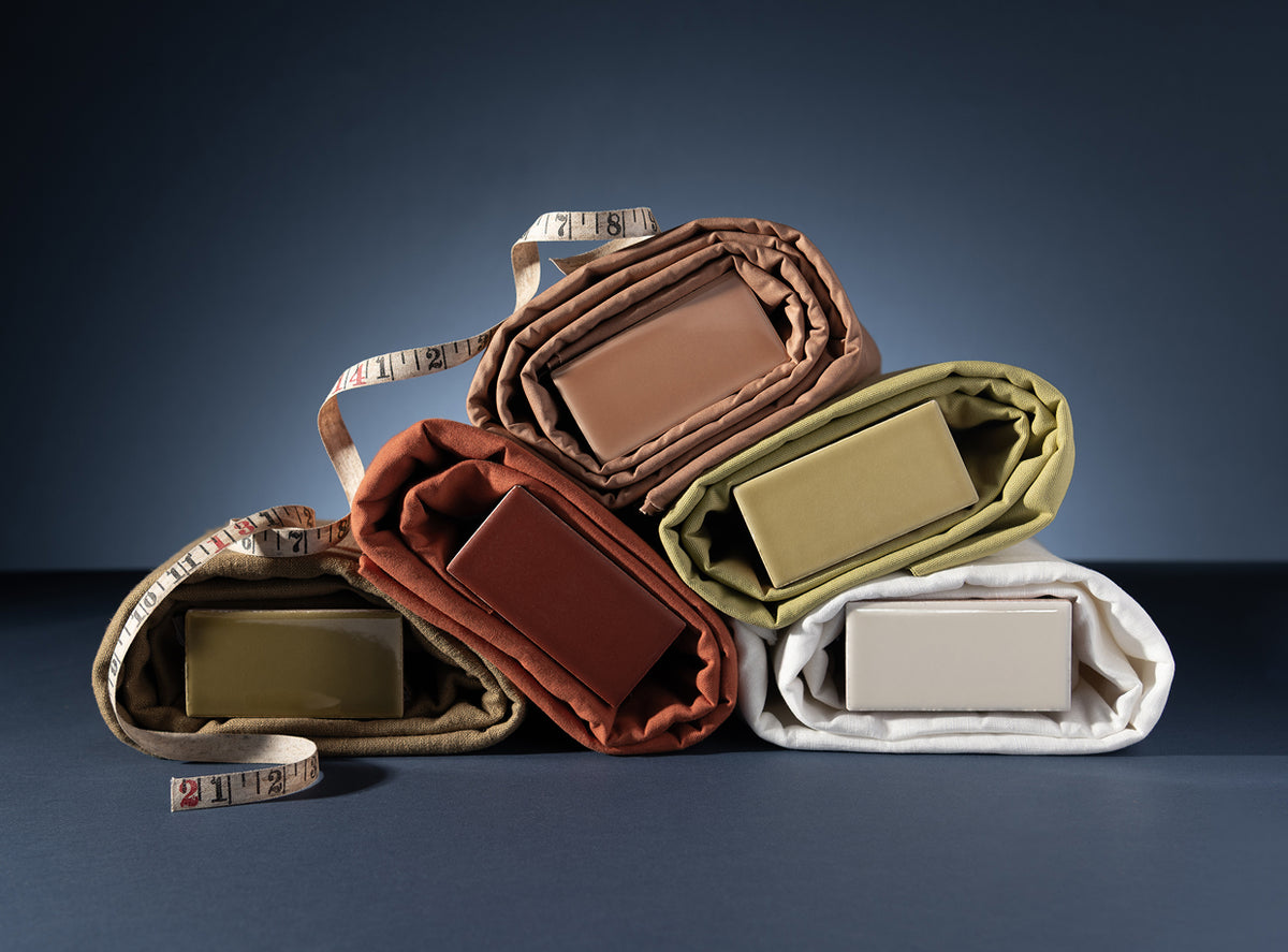 ceramic tile wrapped in fabric with a tape measure in editorial styling