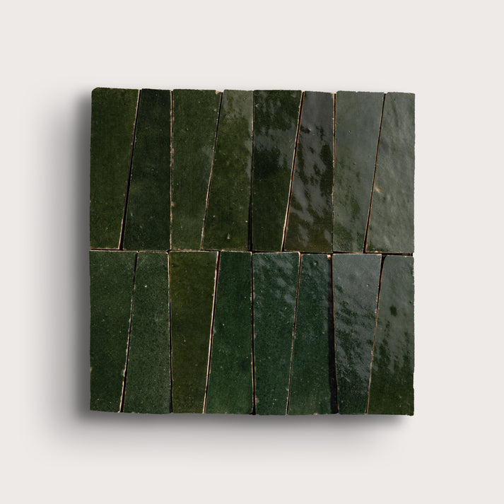 Green zellige tiles arranged in a geometric pattern on a white background