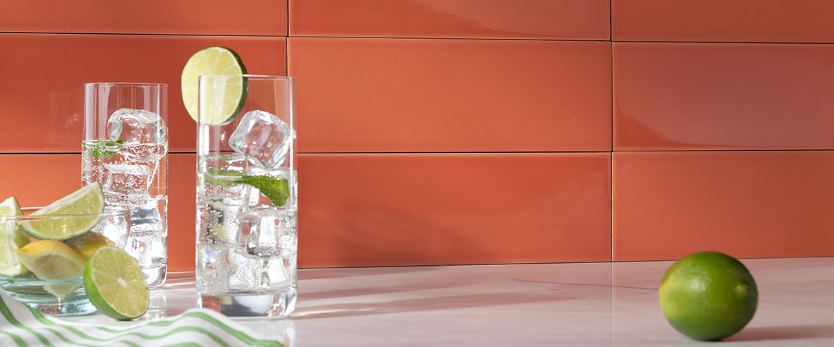 red subway ceramic tile as backsplash styled with water glasses and limes