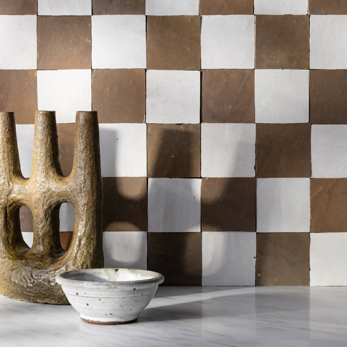 hazel and white checkerboard zellige backsplash tile in kitchen with sculpture in front