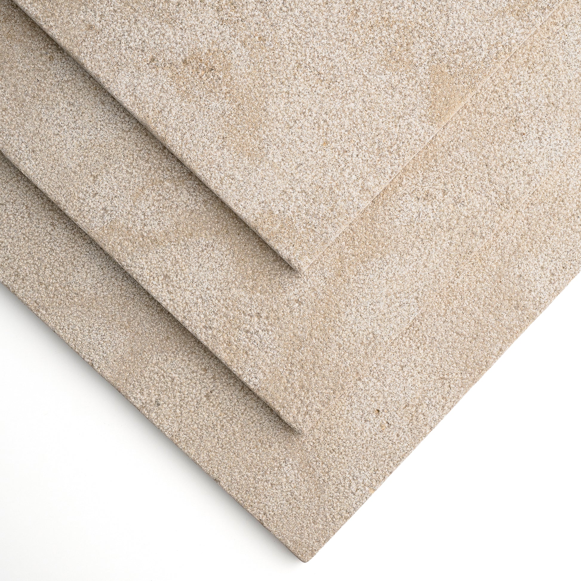 Three overlapping rectangular limestone tile in a warm light beige/taupe, shown on a clean white background.