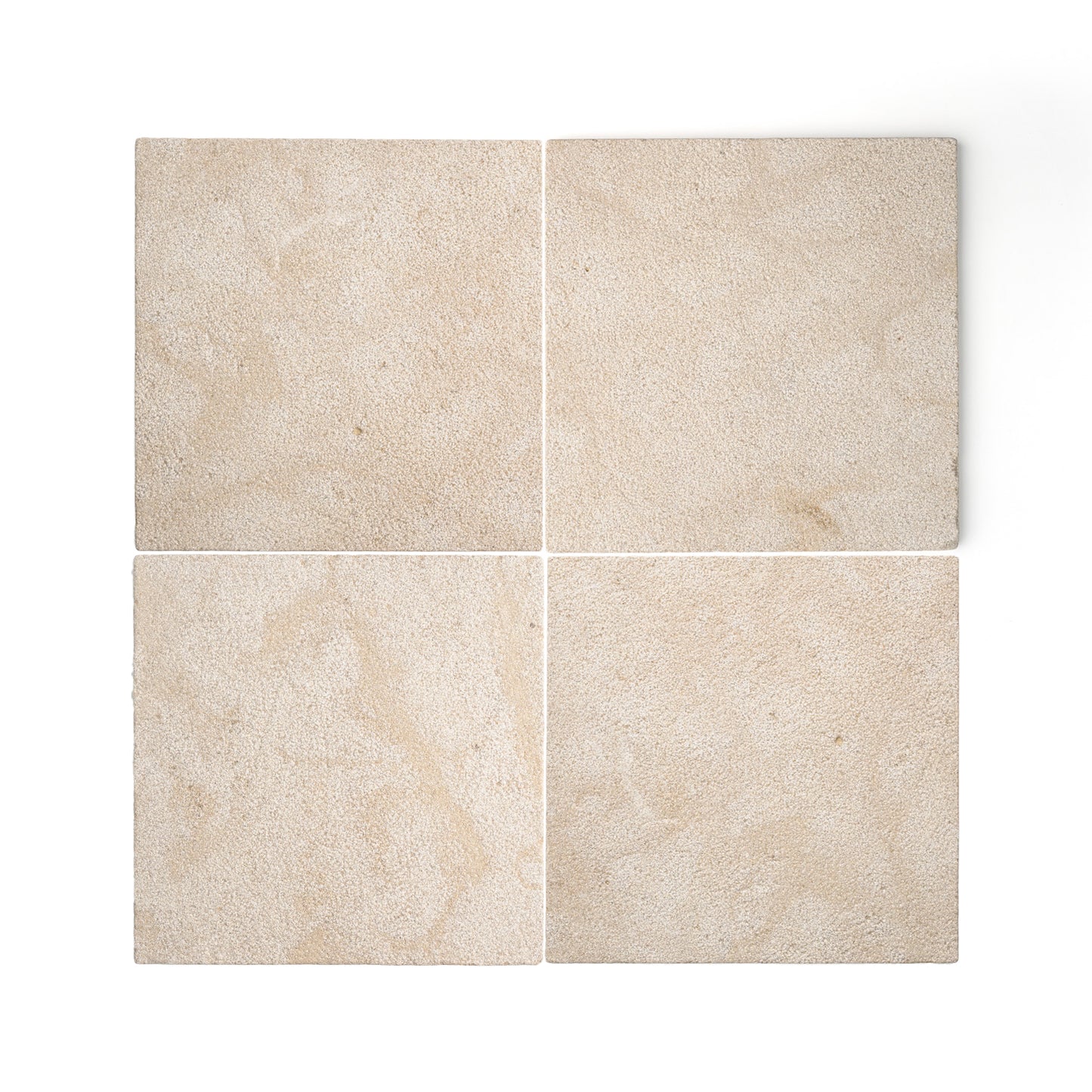 Four square beige limestone tiles arranged in a 2x2 grid on a white background, showing natural stone texture and subtle tonal variation.