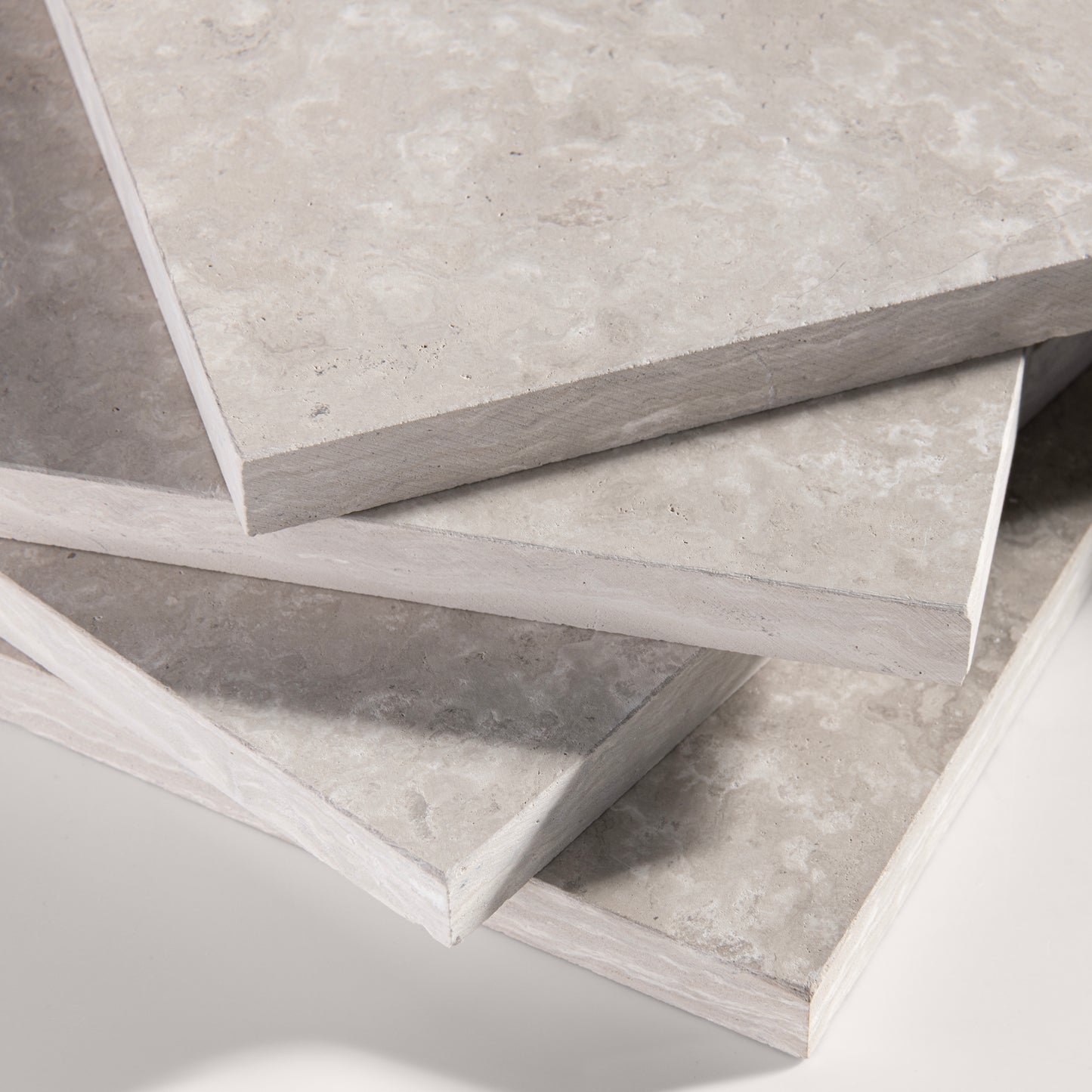 close up angle of Beige limestone tile on a light gray background