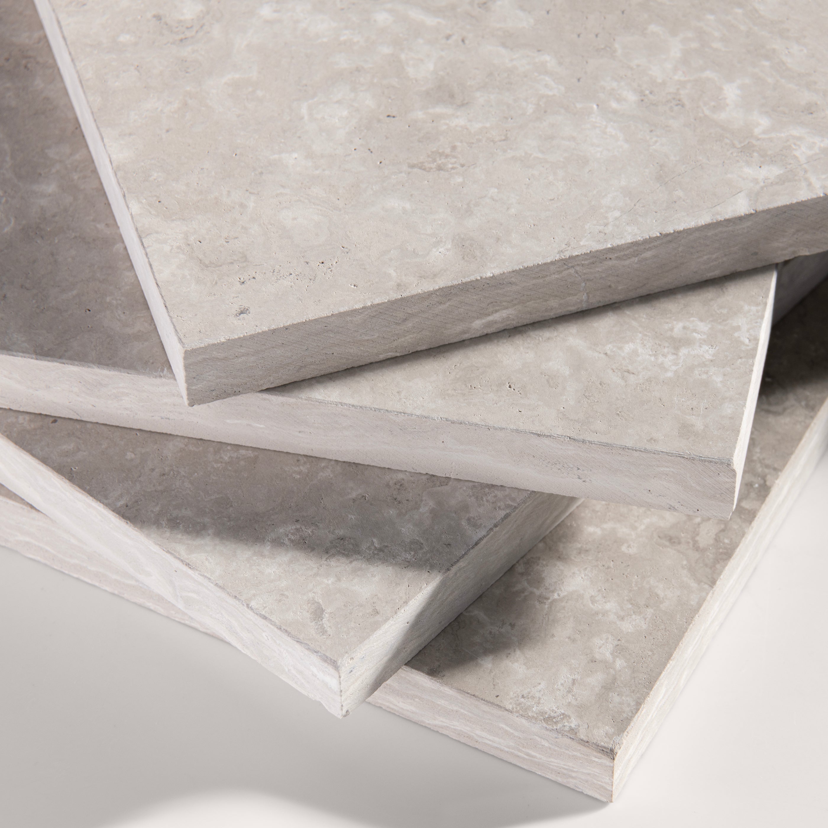 close up angle of Beige limestone tile on a light gray background