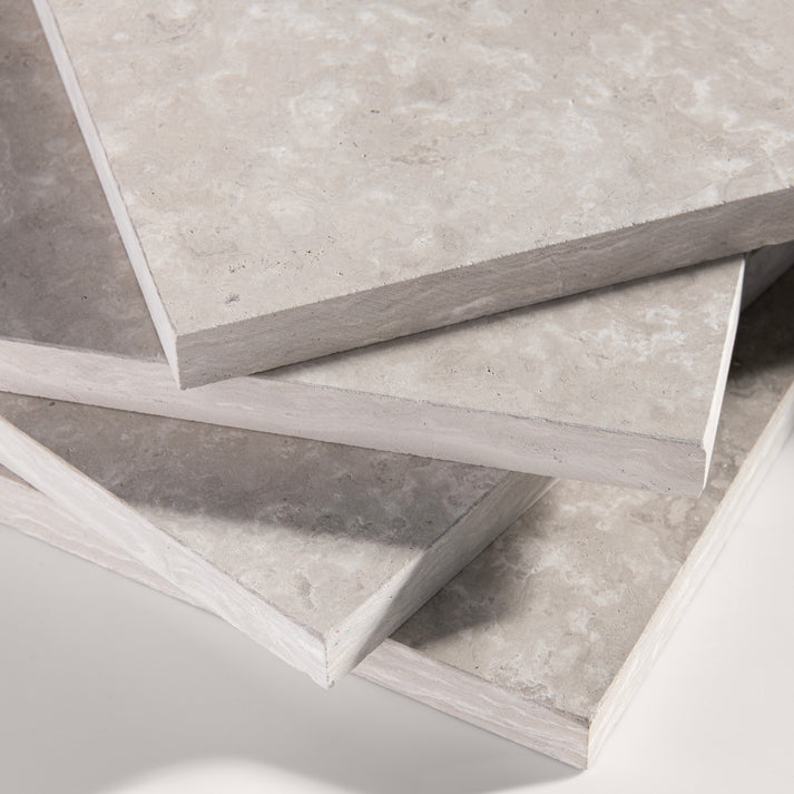 close up angle of Beige limestone tile on a light gray background