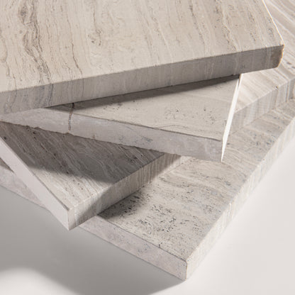 close up angle of Beige limestone tile on a light gray background