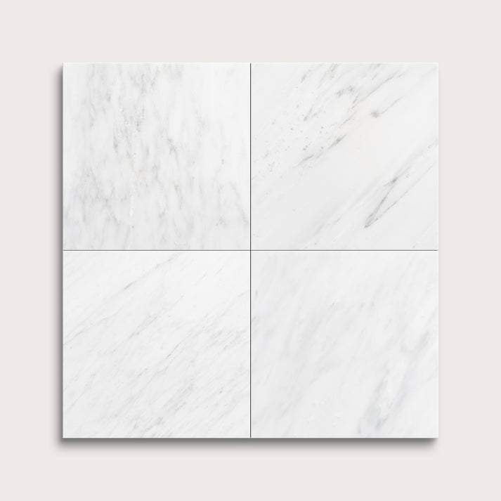 White casablanca carrara marble tiles arranged in a grid pattern on a light gray background