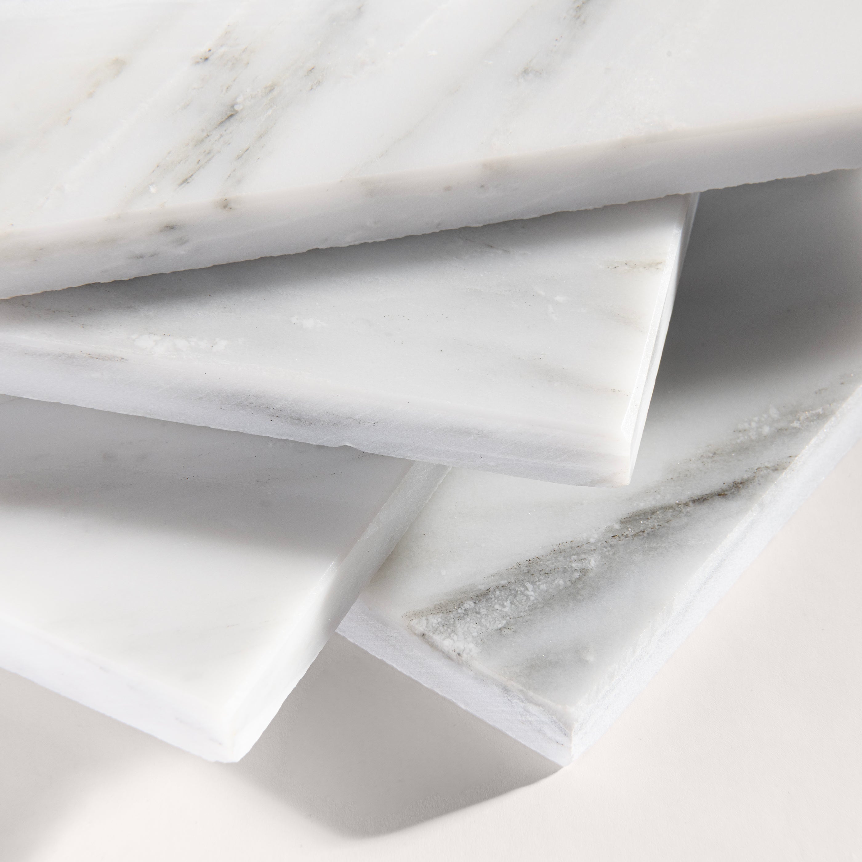 close up angle of White casablanca carrara marble tiles on a light gray background