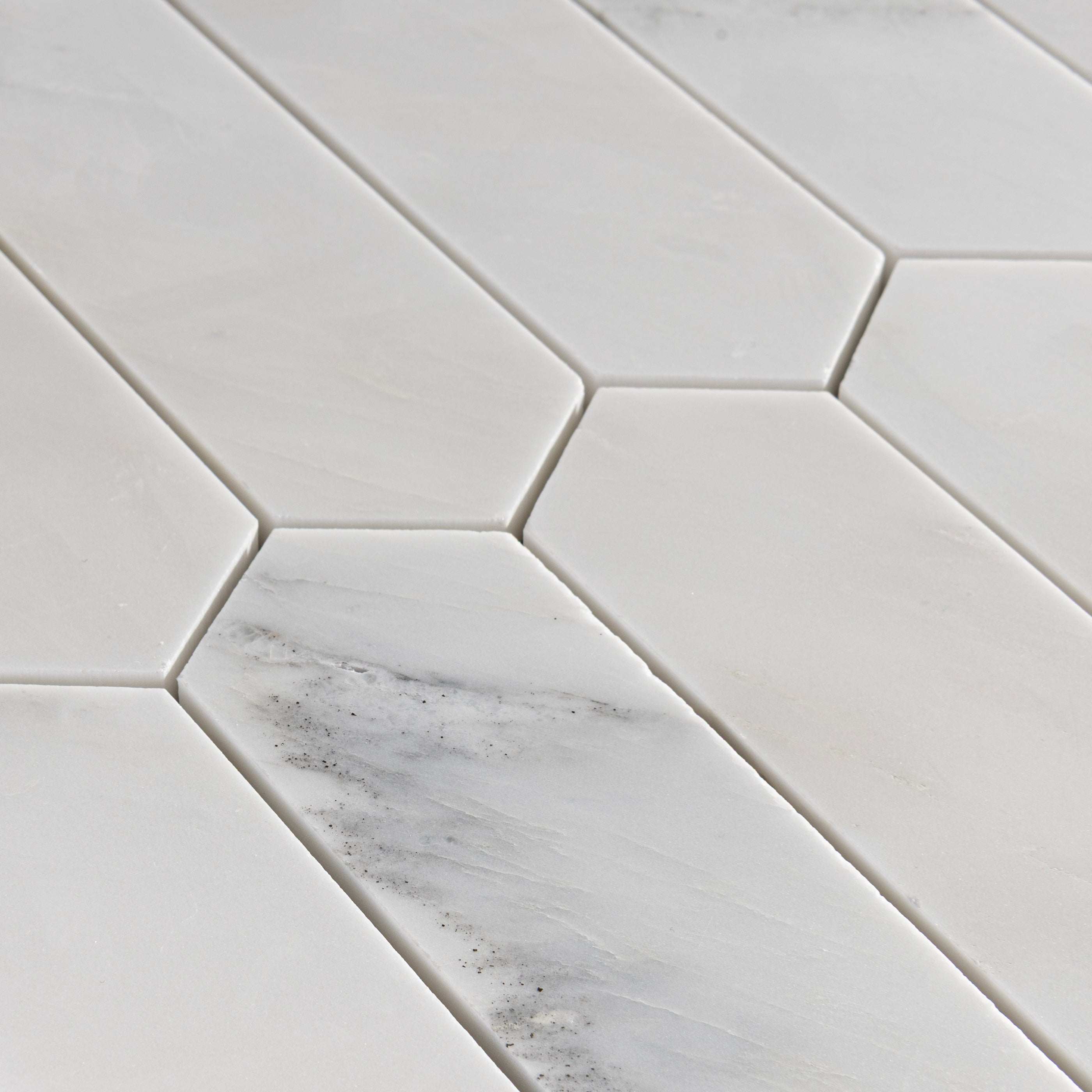 Hexagonal casablanca carrara marble mosaic tile on a light gray background