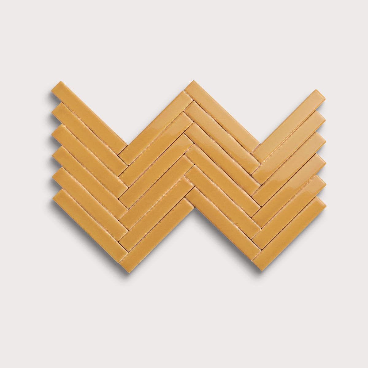 Gambol Gold ceramic tile, 1 by 6 inch herringbone mosaic, gloss finish
