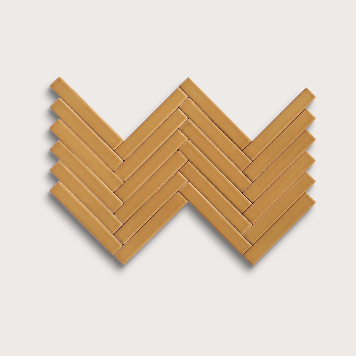 Gambol Gold ceramic tile, 1 by 6 inch herringbone mosaic, matte finish