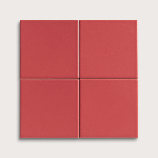 Four red square ceramic tiles on a light gray background