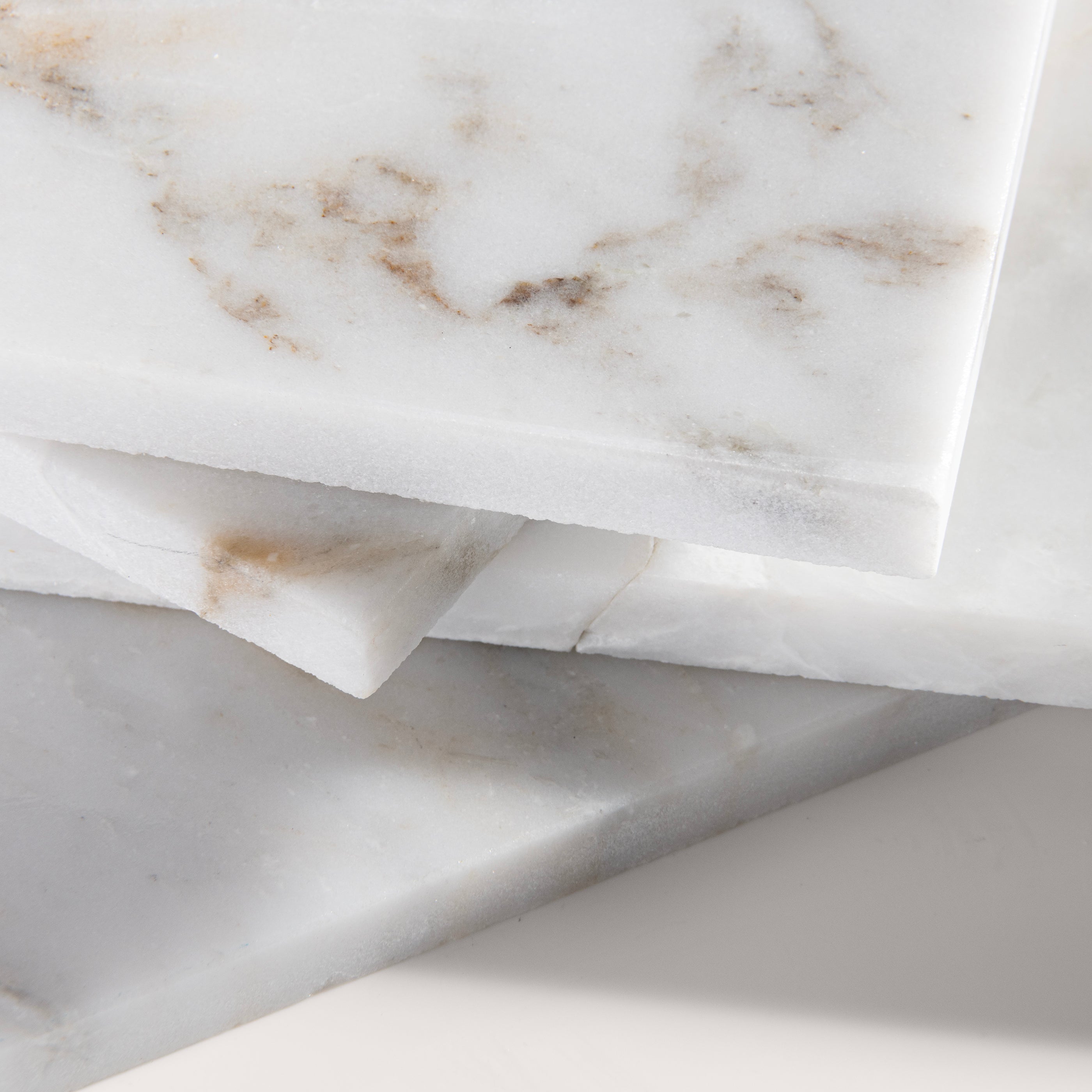 close up angle of casablanca gold White marble tiles on a light gray background