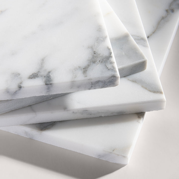 close up angle of italian statuary white and grey marble tiles  on a light gray background