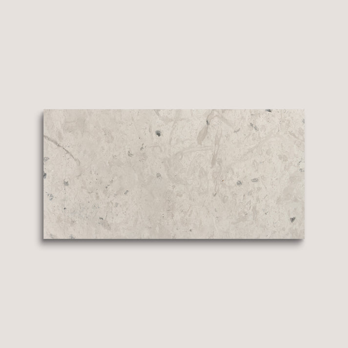 Rectangular limestone tile with a beige and gray marbled pattern on a light gray background