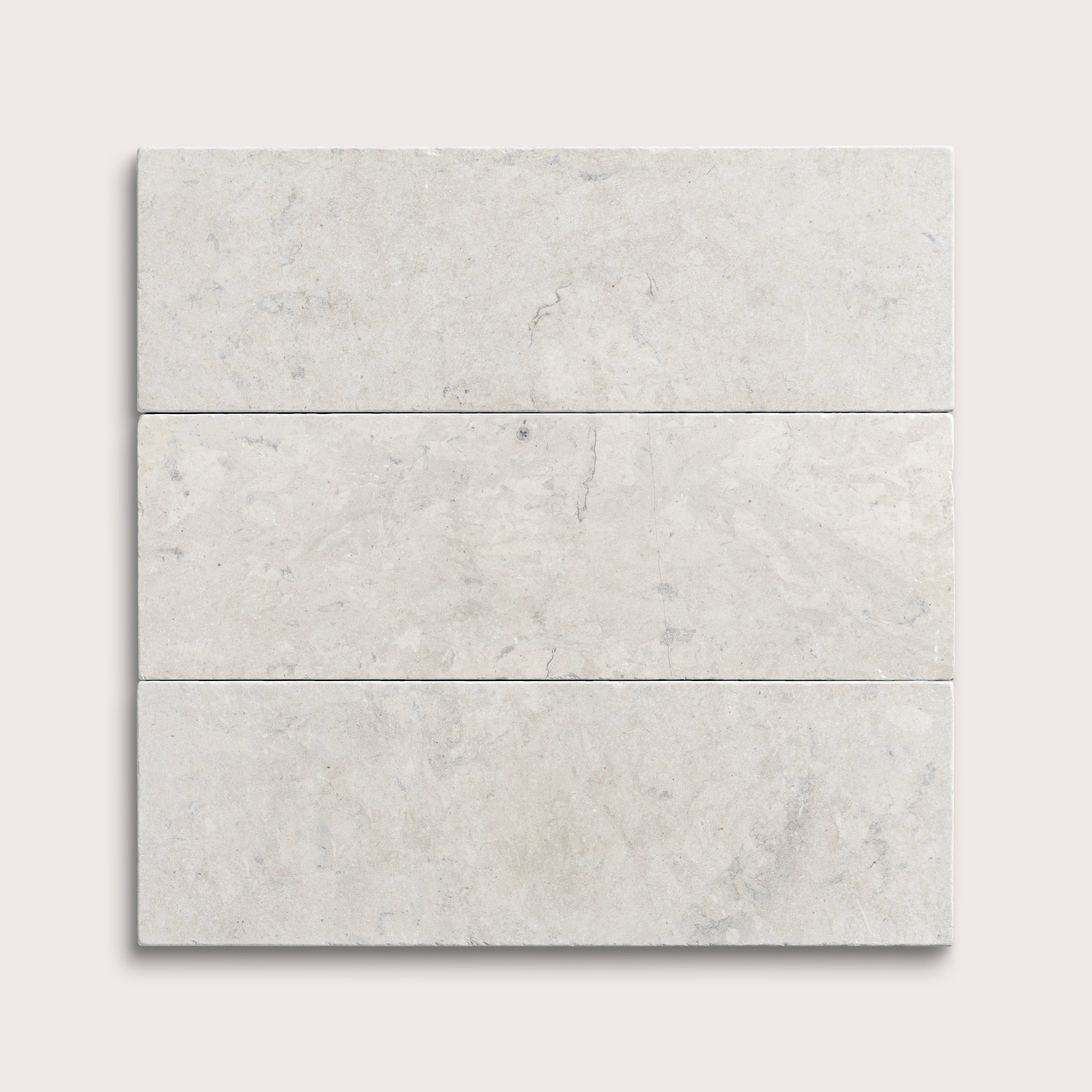 three rectangular tiles with a grey limestone pattern on a white background