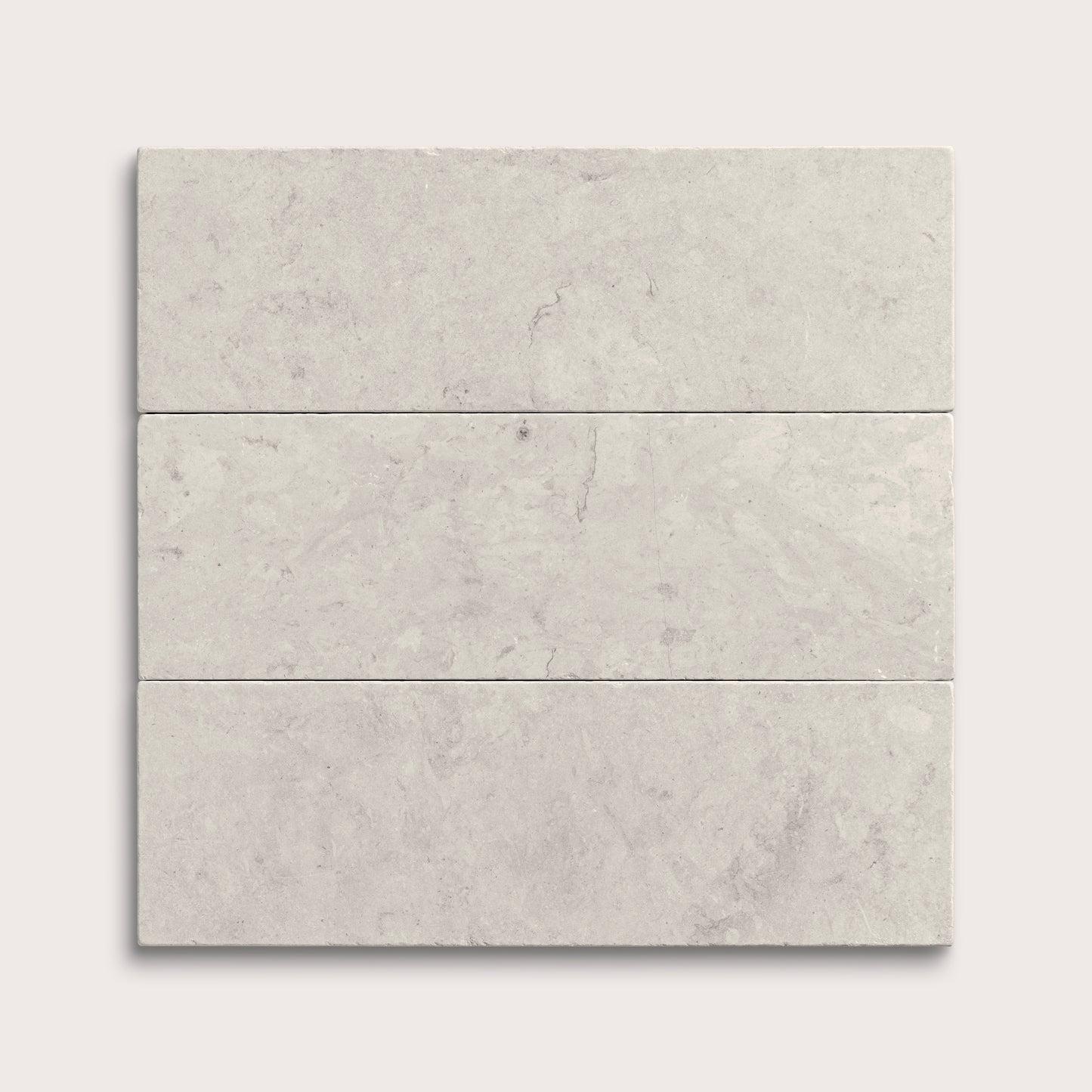 Three gray limestone tiles arranged in a horizontal line on a white background