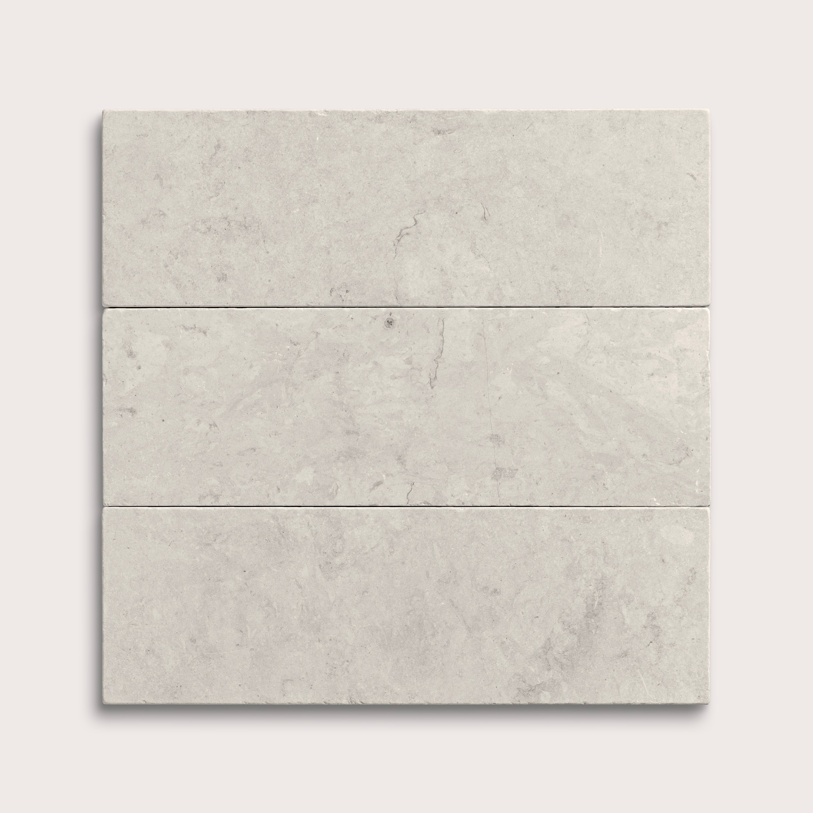 Three gray limestone tiles arranged in a horizontal line on a white background