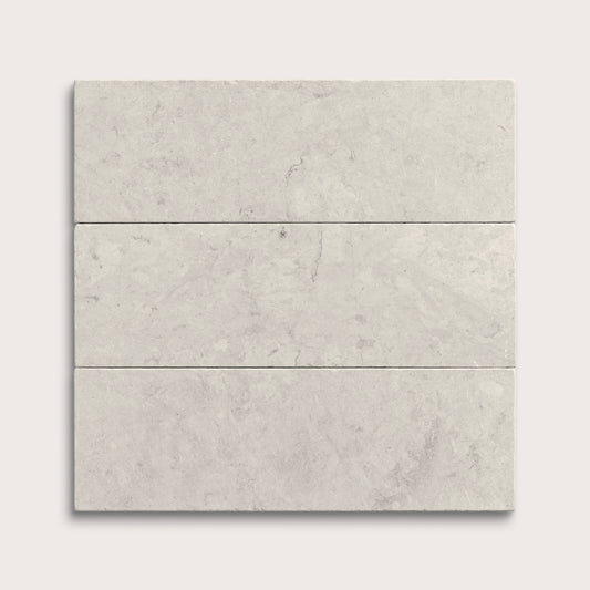 Three gray limestone tiles arranged in a horizontal line on a white background