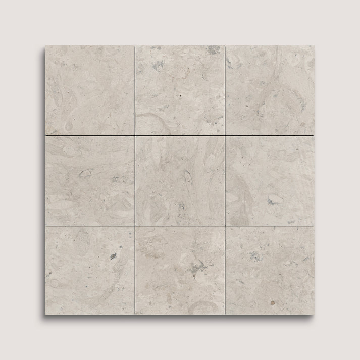 Nine square tiles with a beige and gray limestone pattern on a light gray background