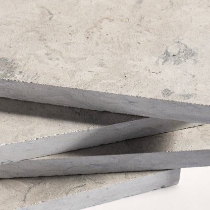 close up of tiles with a grey limestone pattern on a white background